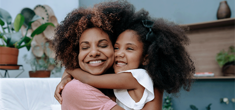 Mother and daughter with natural textured hair hugging
